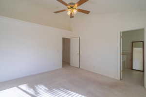 Spare room with light carpet, ceiling fan, and lofted ceiling