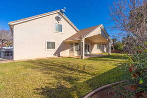 Rear view of house featuring a yard and a patio