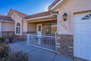 View of exterior entry featuring covered porch