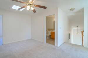 Spare room with light carpet and ceiling fan with notable chandelier