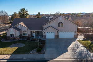 View of front of property with a garage and a front lawn