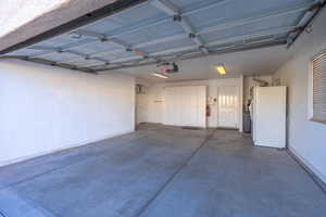 Garage featuring white fridge and a garage door opener