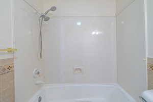 Bathroom with shower / bathing tub combination and toilet