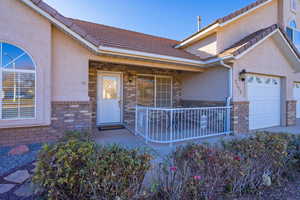 View of exterior entry featuring a porch and a garage