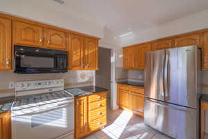 Kitchen with tasteful backsplash, white electric range oven, crown molding, light tile patterned floors, and stainless steel refrigerator