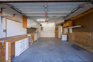 Garage with electric panel and a garage door opener