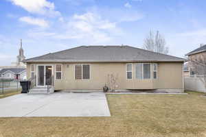 Back of property with a patio and a lawn