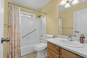 Full bathroom with tile patterned flooring, shower / tub combo, vanity, and toilet