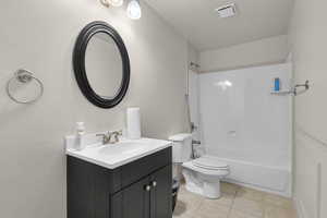 Full bathroom featuring tile patterned flooring, vanity, shower / bath combination, and toilet