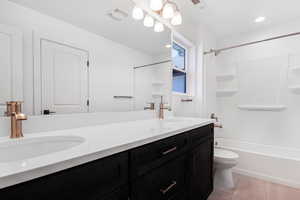 Full bathroom with vanity, bathtub / shower combination, and toilet