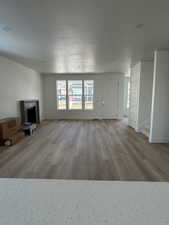 Unfurnished living room with a fireplace and light hardwood / wood-style floors