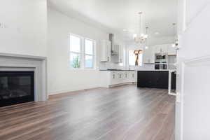 Kitchen featuring backsplash, hanging light fixtures, appliances with stainless steel finishes, a kitchen island, and white cabinetry