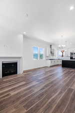 Unfurnished living room with a chandelier and dark hardwood / wood-style floors