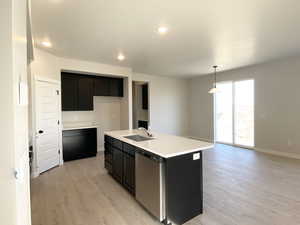 Great Room featuring a center island with sink, open floor plan, stainless steel appliances, and quartz countertops