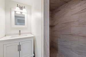 Bathroom featuring vanity and tiled shower