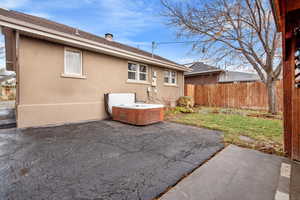 Rear view of house featuring a patio and a hot tub