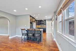 Kitchen with a center island, stainless steel appliances, tasteful backsplash, a breakfast bar, and dark brown cabinets