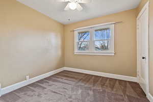 Empty room with carpet floors and ceiling fan