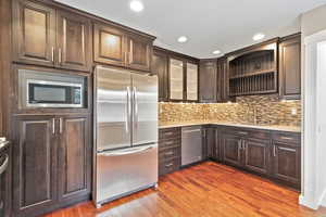 Kitchen with sink, dark wood-type flooring, dark brown cabinets, and appliances with stainless steel finishes