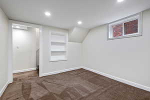 Interior space with carpet flooring and built in shelves