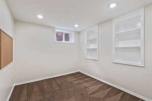 Carpeted empty room featuring built in shelves