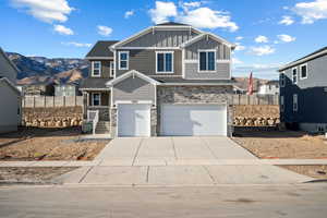 View of front of home with a mountain view and a garage