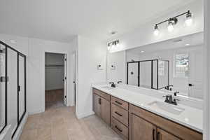 Bathroom with tile patterned flooring, vanity, and a shower with shower door