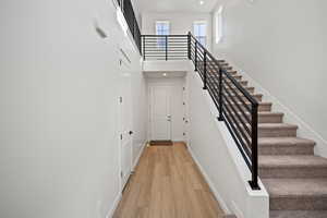 Staircase featuring hardwood / wood-style floors and a towering ceiling