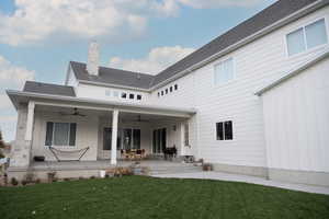 Rear view of property featuring a yard and patio area