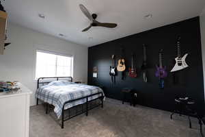 Bedroom featuring carpet floors, ceiling fan, and wood walls