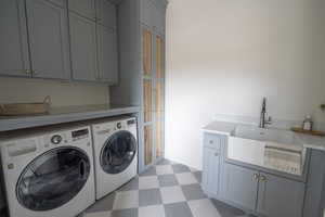 Laundry room featuring sink, cabinets, and  washer and dryer