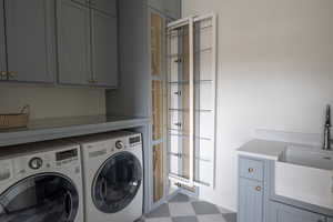 Washroom with sink, cabinets, and washer and dryer