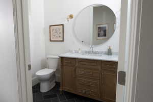 Bathroom with toilet, vanity, and tile patterned flooring