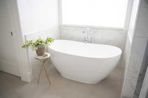 Master Bathroom with a tub and tile patterned floors