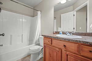 Full bathroom with toilet, shower / tub combo, vanity, and tile patterned floors