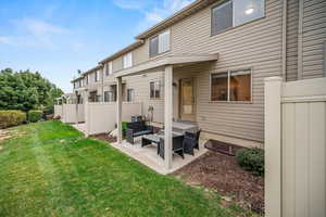 Rear view of house with a yard, a patio, and central AC