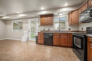 Kitchen with sink, light tile patterned flooring, and black appliances