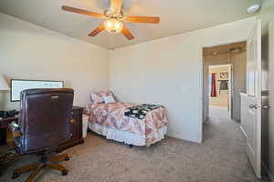 Carpeted bedroom featuring ceiling fan