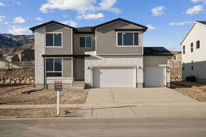 View of front of property with central AC unit, a mountain view, and a garage