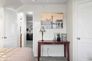 Carpeted bedroom featuring vaulted ceiling