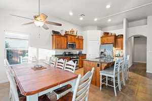 Dining area with ceiling fan, dark tile patterned floors, and sink