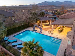 View of pool with a mountain view, a patio area, and a water slide