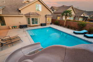 Pool at dusk with a patio area