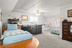 Bedroom with ceiling fan, carpet, and lofted ceiling