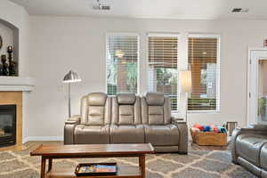 Living room with a fireplace and wood-type flooring