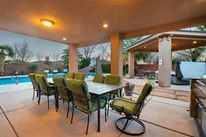 Patio terrace at dusk featuring a fenced in pool