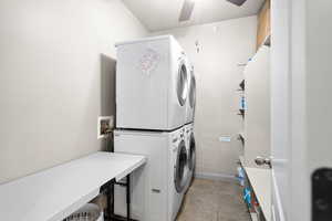 Washroom featuring ceiling fan and stacked washer / drying machine