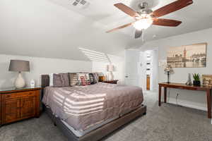 Carpeted bedroom featuring ceiling fan and lofted ceiling