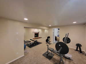 Exercise area featuring carpet and a brick fireplace