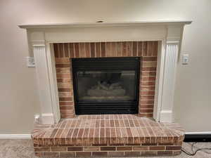 Carpet flooring and a brick fireplace